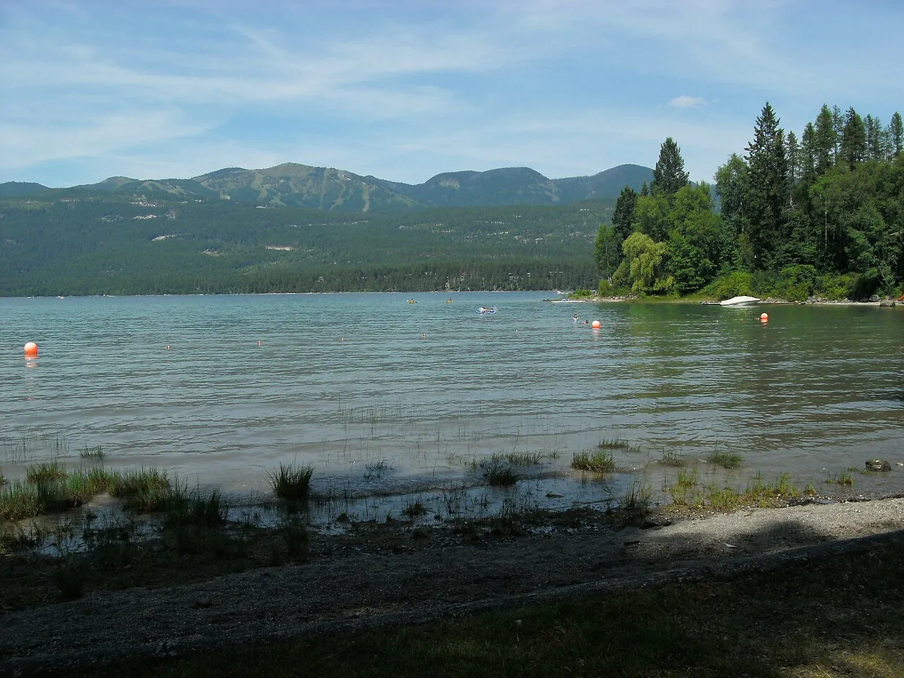 Swimming area at Whitefish Lake State Park, Montana, showing Big Mountain Ski Resort trails.