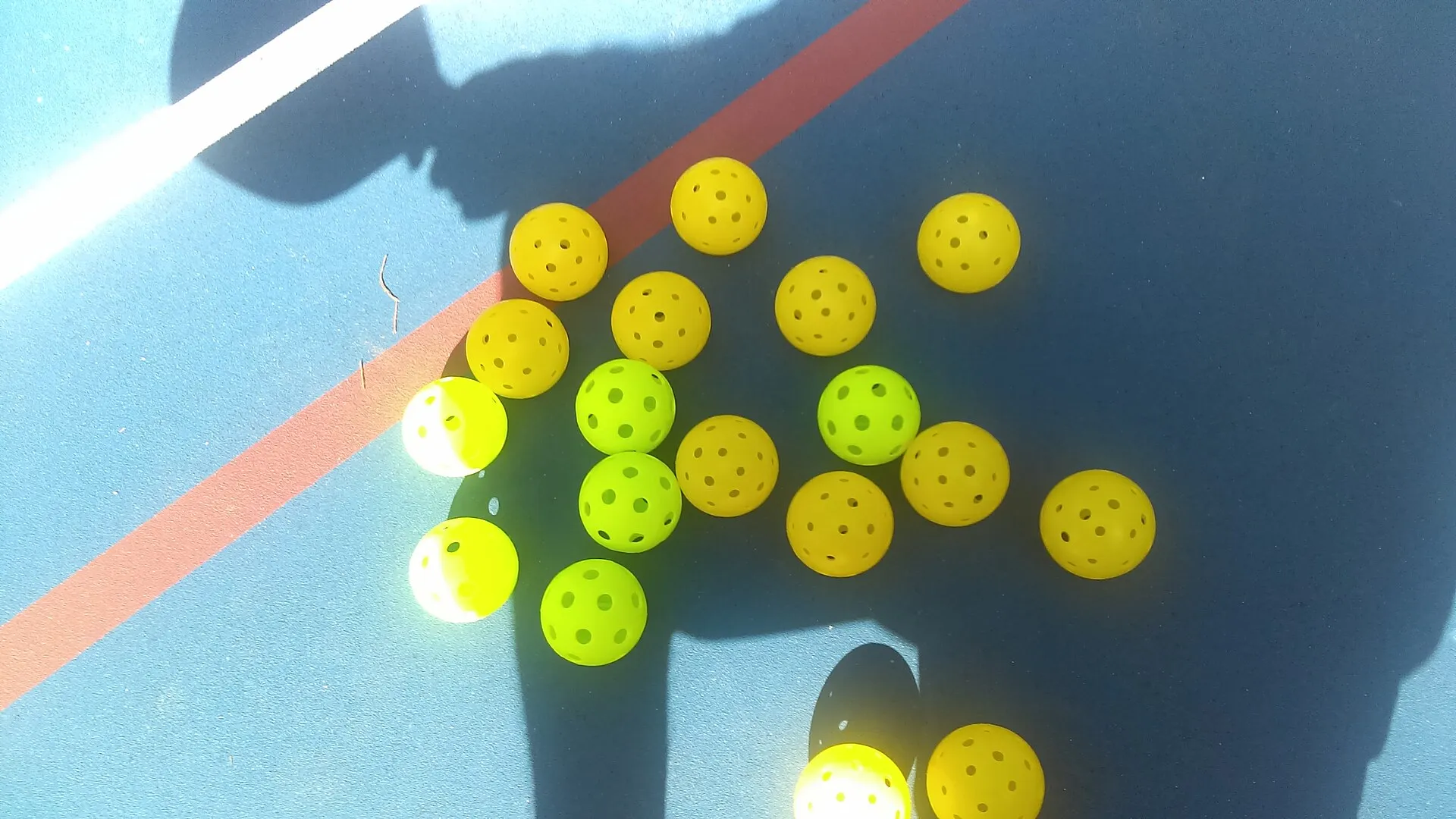 Pickleballs scattered on a court