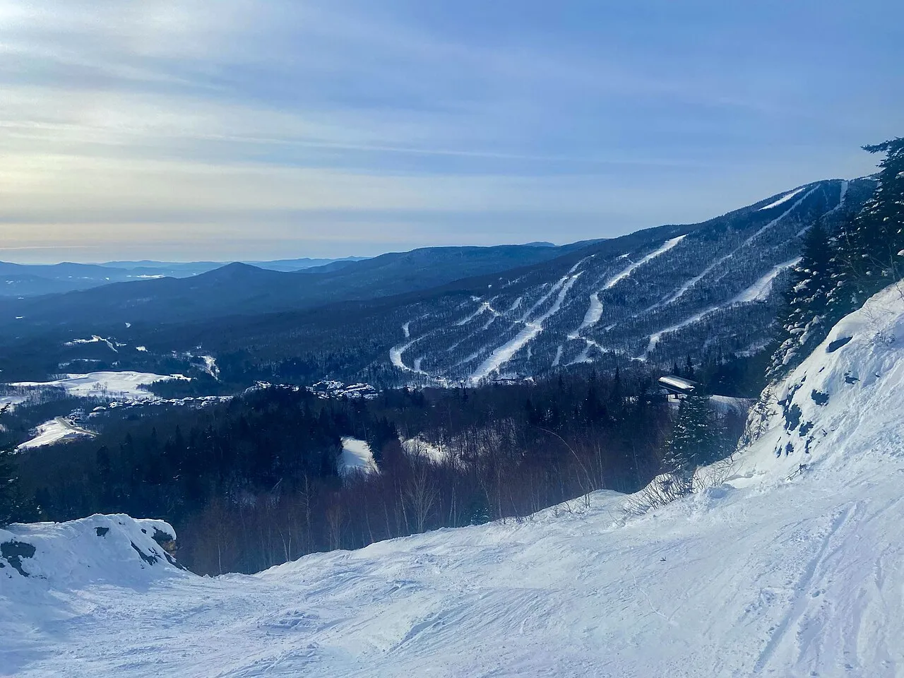 Image taken at Stowe VT of moguls on a trail and the adjacent mountain