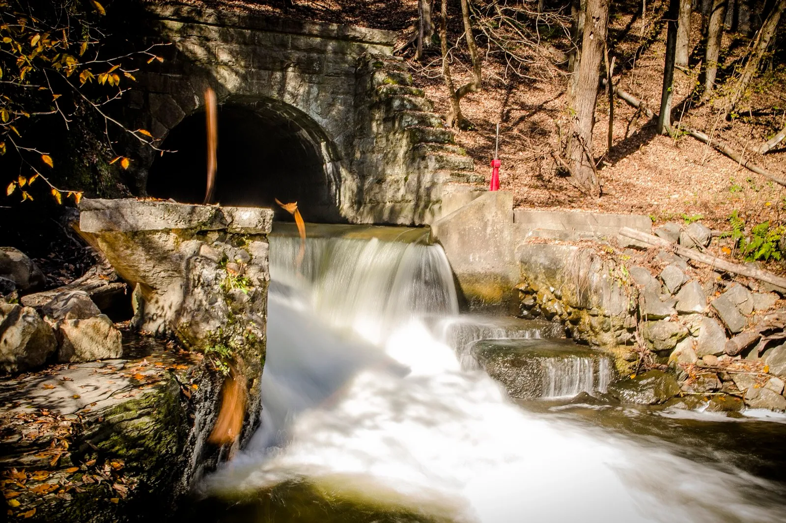 Cascade under a stone arch in Saratoga Spa State Park in autumn