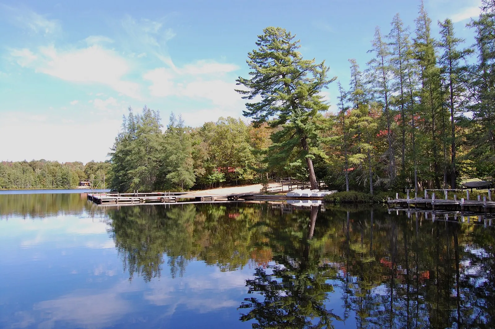 Calm lake with a dock and evergreens (nearby Old Forge)